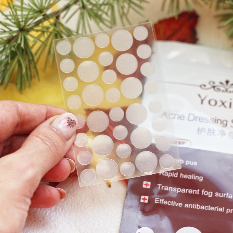 Clear patch sheet showing various sizes of invisible acne patches for blemish and pimple care.
