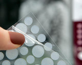 Close-up of a hand holding Jenalya invisible acne patches designed for blemish and pimple care.